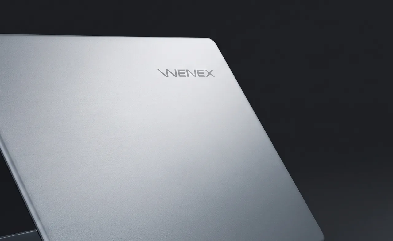 The closed lid of the WENEX MyBook in silver-grey metal, the WENEX wordmark on the upper right of the lid
